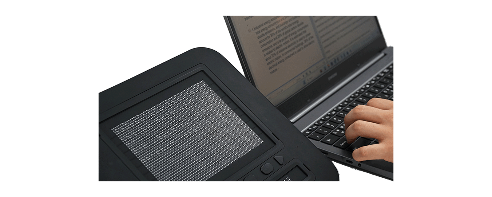 Dot Pad X affiancato a un computer portatile: una persona digita sulla tastiera mentre il documento viene riprodotto in rilievo sull'area tattile.