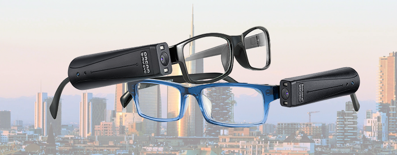 Due paia di occhiali, con montatura nera e blu, con il dispositivo OrCam MyEye agganciato alla stanghetta